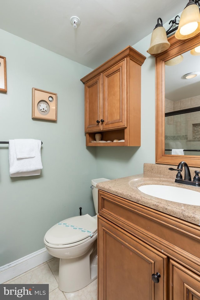 bathroom with tile patterned floors, a shower with door, vanity, and toilet