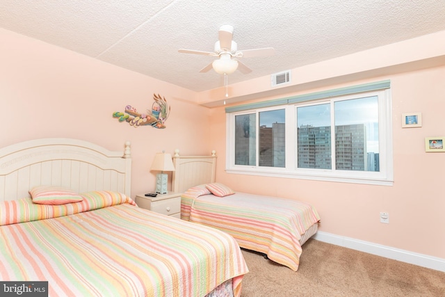 bedroom with carpet, a textured ceiling, and ceiling fan