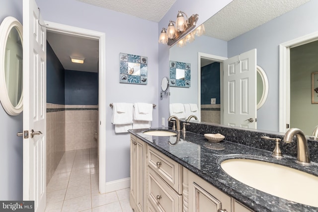 bathroom with vanity, a textured ceiling, and tile patterned floors