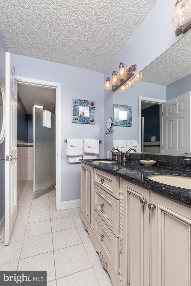 bathroom with tile patterned flooring, vanity, and a textured ceiling