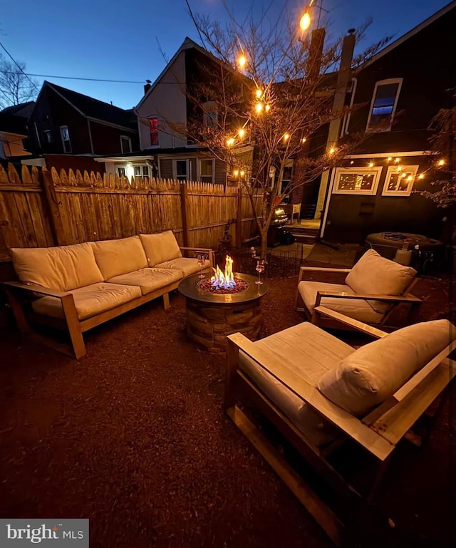 view of patio with an outdoor living space with a fire pit and fence