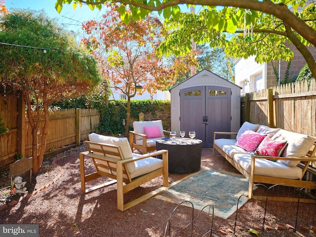 view of patio featuring an outbuilding, a storage unit, a fenced backyard, and an outdoor hangout area