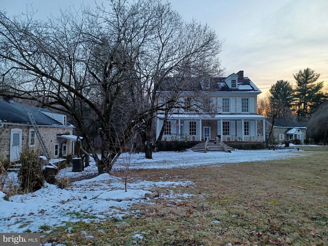 colonial-style house with a yard and a porch