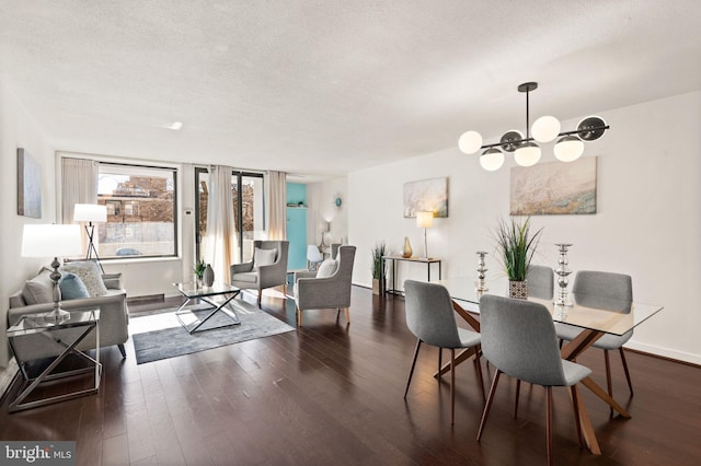 dining area with dark hardwood / wood-style floors, a textured ceiling, and a notable chandelier