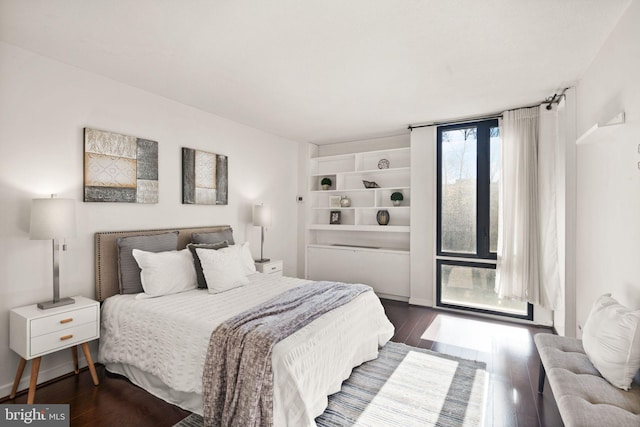 bedroom with dark hardwood / wood-style flooring