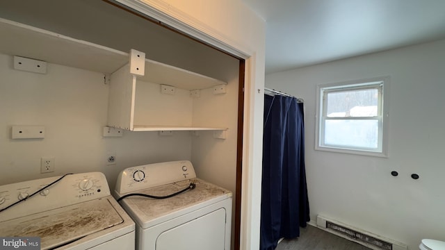 laundry room featuring washing machine and clothes dryer, hardwood / wood-style flooring, and a baseboard heating unit