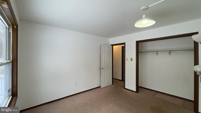 unfurnished bedroom with light carpet and a closet