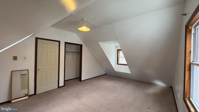 additional living space with light colored carpet and vaulted ceiling