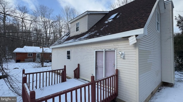 view of snow covered back of property