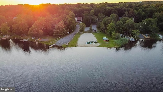 aerial view at dusk featuring a water view