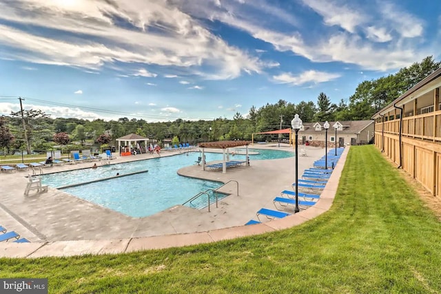 view of swimming pool with a yard and a patio