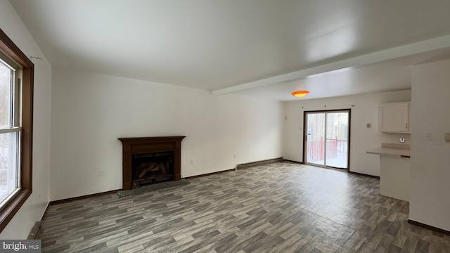 unfurnished living room featuring wood-type flooring and baseboard heating