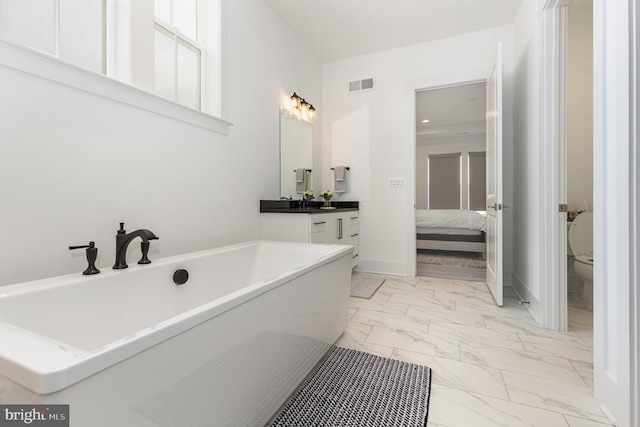 bathroom with vanity, toilet, and a tub