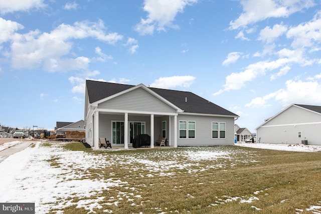 snow covered property with a lawn