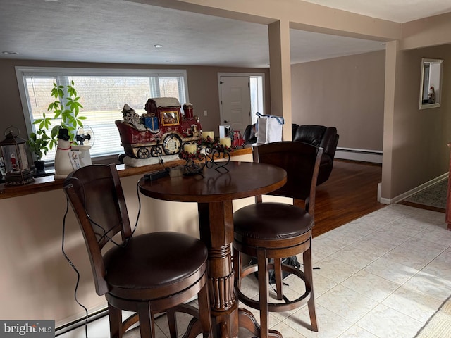 dining area featuring light tile patterned floors and a baseboard heating unit