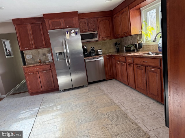 kitchen with decorative backsplash, appliances with stainless steel finishes, stone countertops, and sink