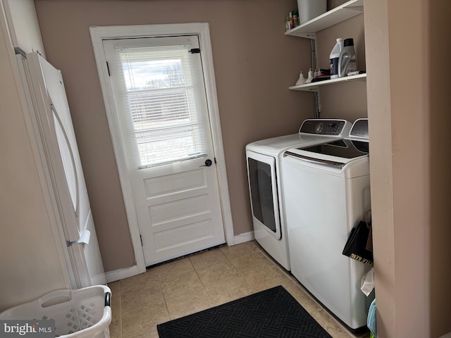 laundry area featuring washing machine and dryer and light tile patterned floors