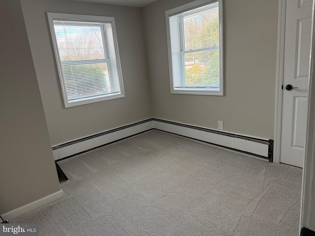 carpeted spare room with a baseboard heating unit