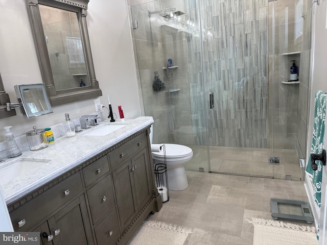 bathroom featuring tile patterned flooring, vanity, an enclosed shower, and toilet