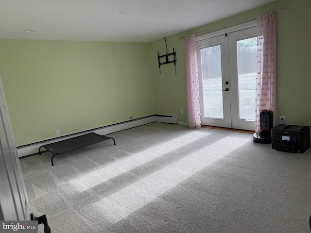 empty room with carpet floors, a baseboard radiator, and french doors