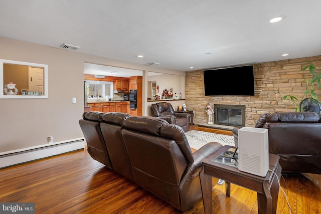 living room with hardwood / wood-style floors, a fireplace, and a baseboard radiator