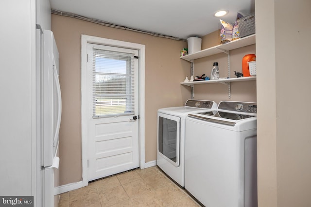 laundry area with washer and clothes dryer and light tile patterned flooring