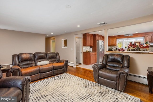 living room featuring hardwood / wood-style floors and a baseboard heating unit