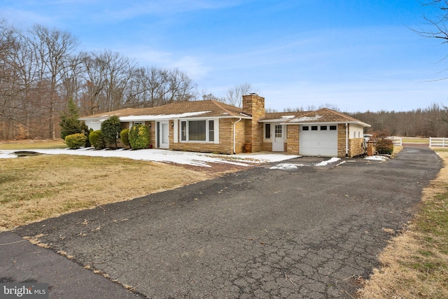 ranch-style home with a front yard and a garage