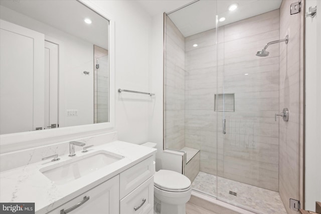 bathroom featuring vanity, toilet, and a shower with shower door