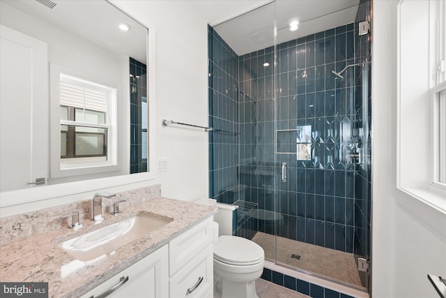 bathroom featuring tile patterned floors, vanity, toilet, and a shower with door