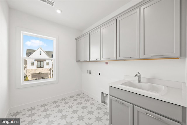 clothes washing area featuring hookup for an electric dryer, hookup for a washing machine, cabinets, and sink