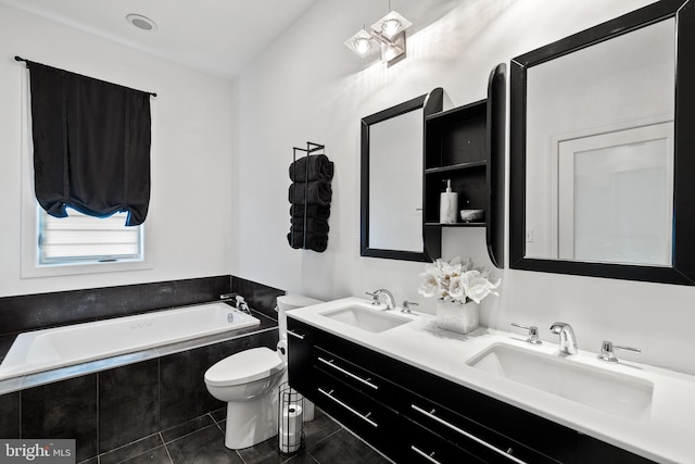 bathroom featuring tile patterned flooring, vanity, toilet, and tiled bath