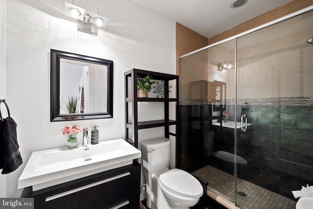 bathroom with vanity, a shower with shower door, and toilet