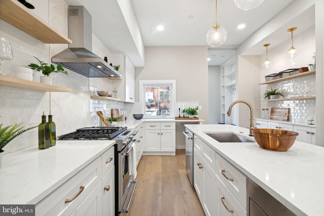 kitchen featuring sink, wall chimney exhaust hood, stainless steel appliances, light stone counters, and white cabinets