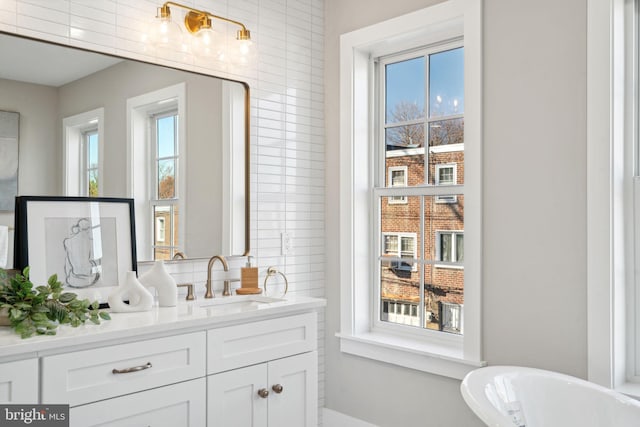 bathroom with vanity, a wealth of natural light, and a bathing tub