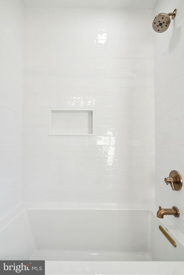 interior details with tiled shower / bath combo