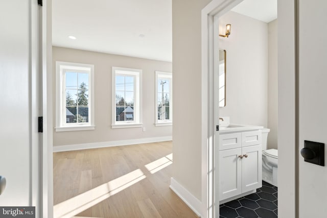 bathroom featuring wood-type flooring, vanity, and toilet