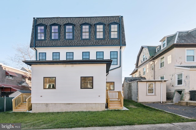 view of front of home featuring a storage unit and a front lawn