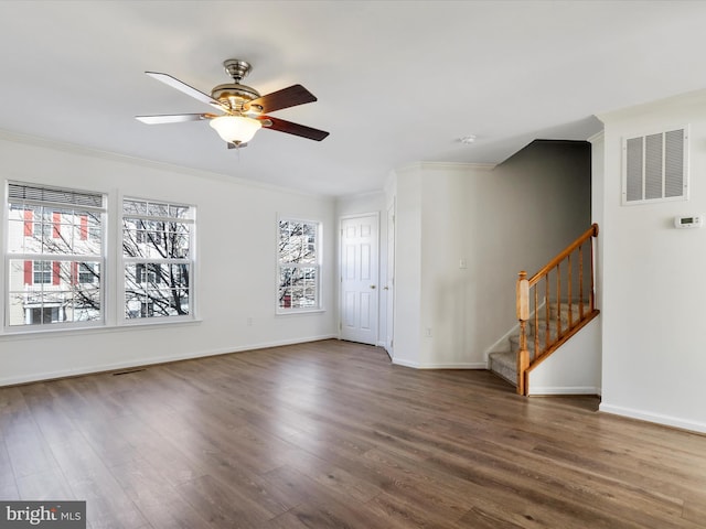 empty room with a healthy amount of sunlight, visible vents, dark wood finished floors, and stairway