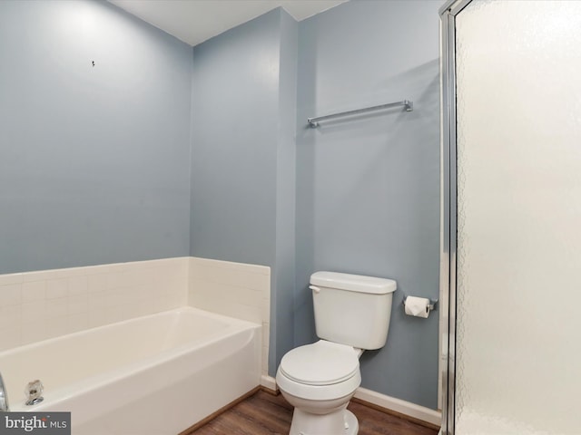 full bath with wood finished floors, toilet, baseboards, and a bath