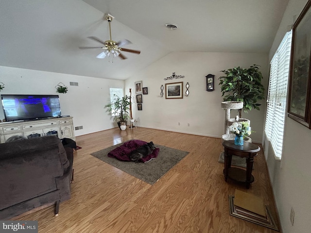 living room with light wood-type flooring, vaulted ceiling, and ceiling fan