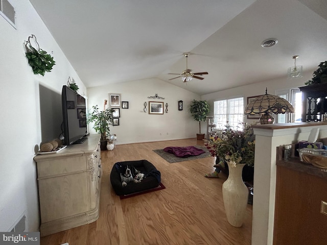 living room featuring hardwood / wood-style flooring, vaulted ceiling, and ceiling fan