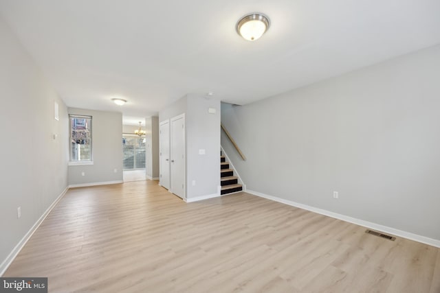 unfurnished room with light hardwood / wood-style floors and a notable chandelier