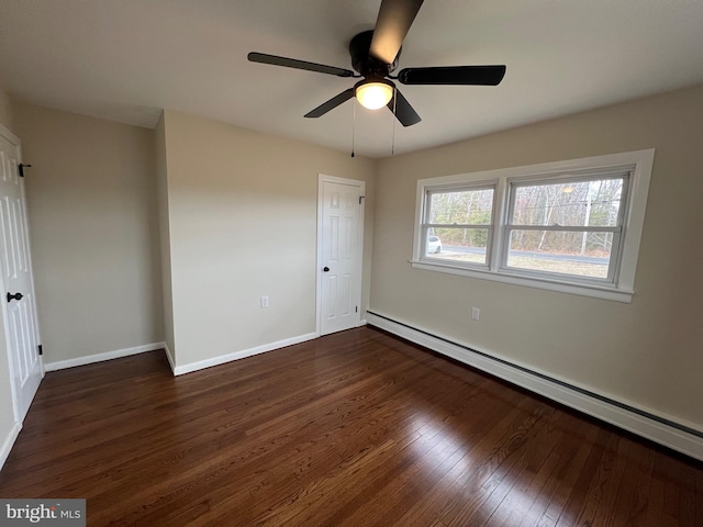 unfurnished bedroom featuring ceiling fan, a baseboard heating unit, and dark hardwood / wood-style flooring