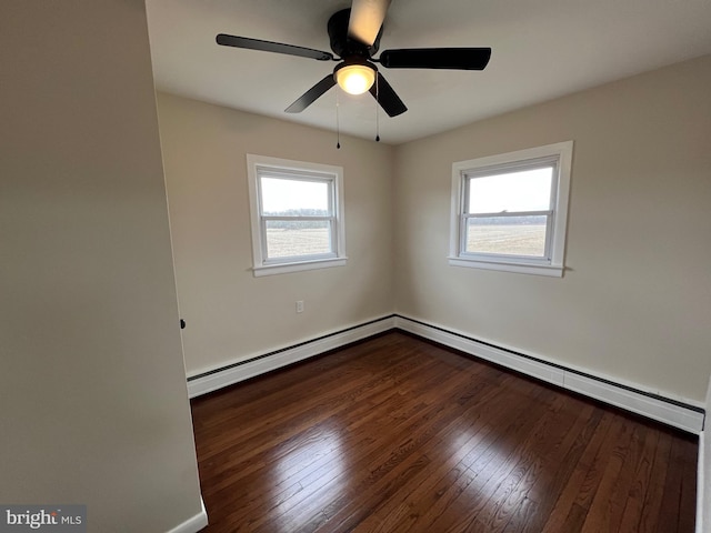 empty room with baseboard heating, a wealth of natural light, dark hardwood / wood-style floors, and ceiling fan