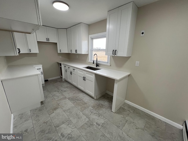 kitchen with sink, white cabinetry, and a baseboard heating unit