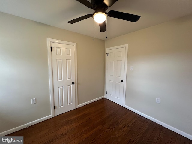 unfurnished bedroom with ceiling fan and dark hardwood / wood-style flooring