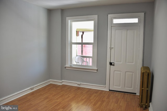 doorway to outside featuring radiator heating unit and light wood-type flooring