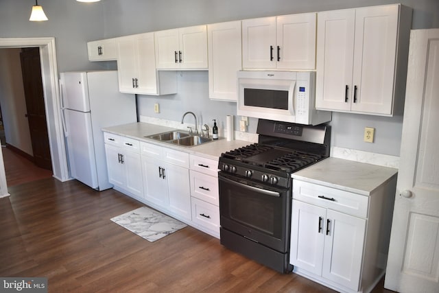 kitchen with sink, white cabinets, dark wood-type flooring, and white appliances