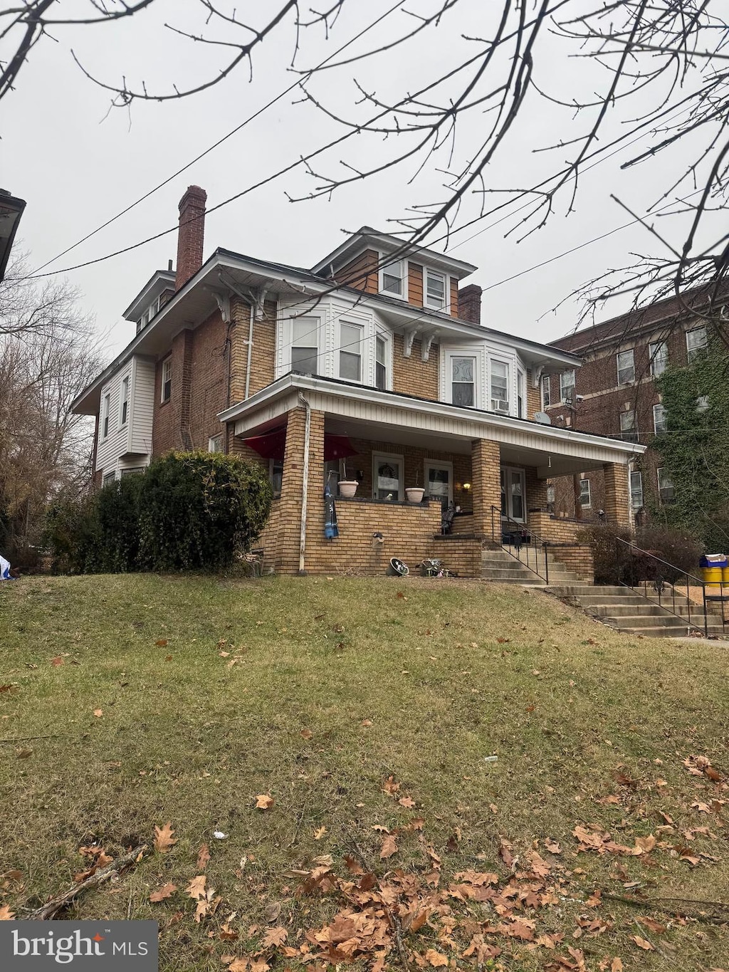 view of front of house featuring covered porch and a front yard